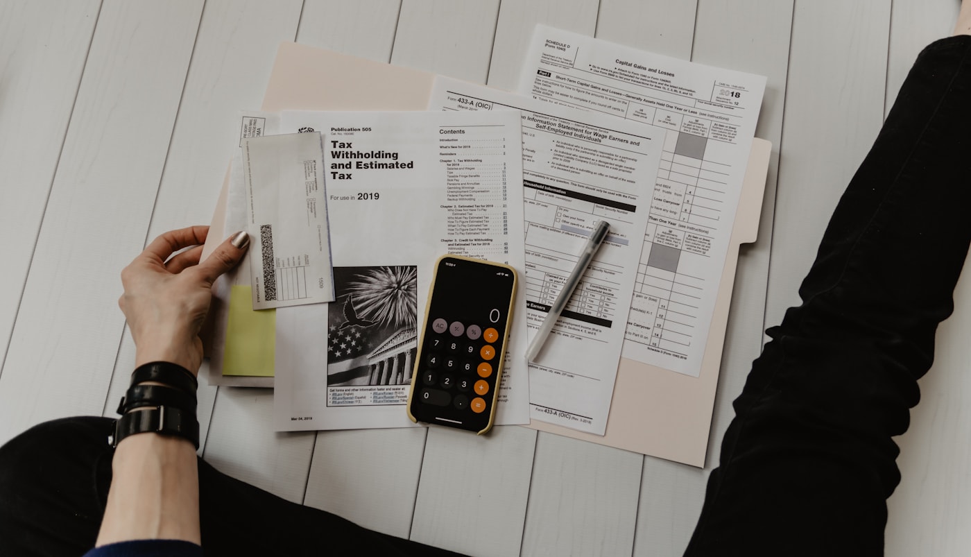 A person reviewing a household budget and financial documents at a desk